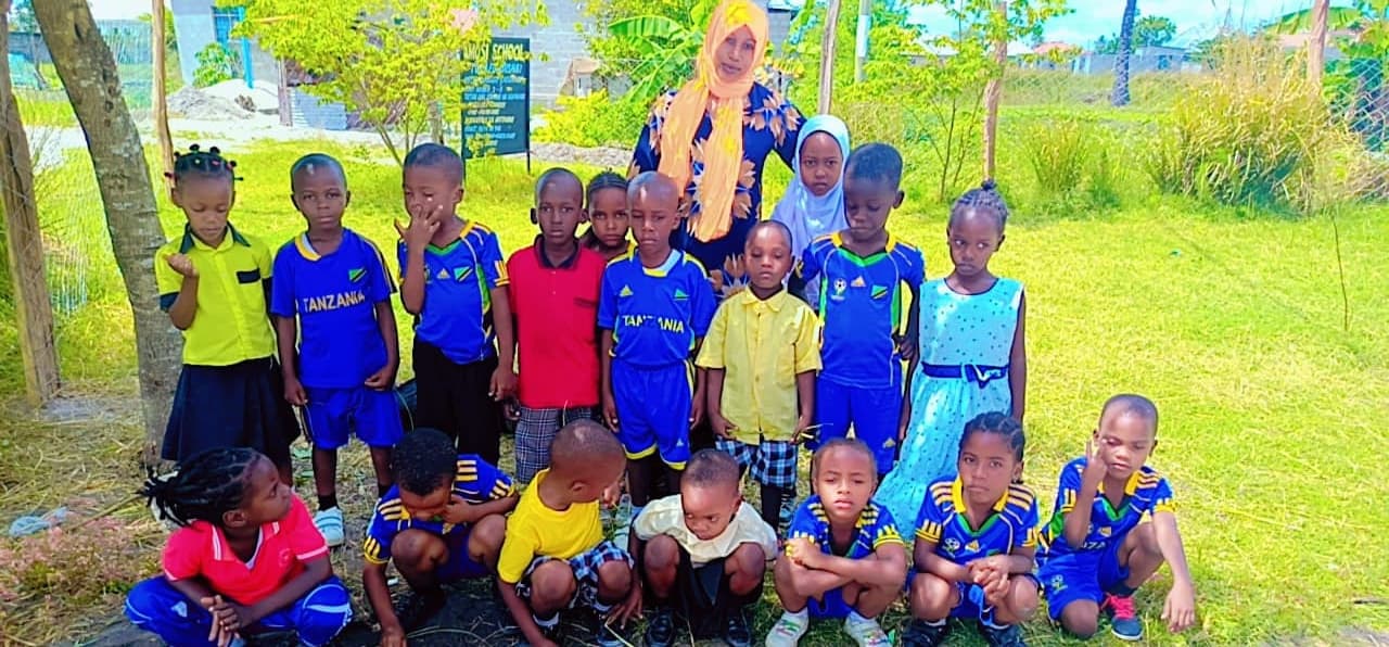 Amosi Schools nursery learner with a caring teacher